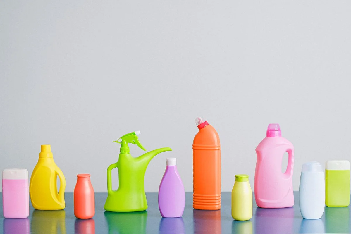 Produtos de limpeza domésticos organizados, incluindo detergente neutro e frascos para higienizar o comedouro automático